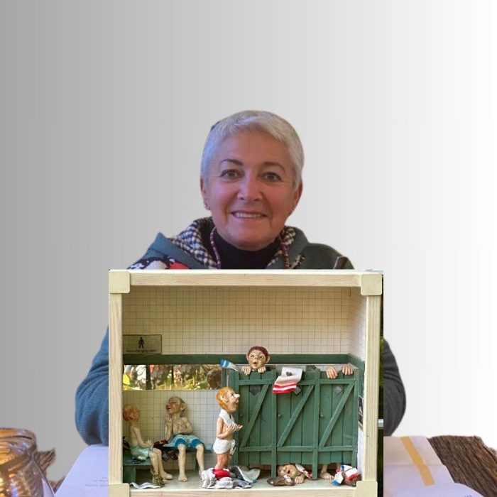 This humorous ceramic men's changing room sculpture by Dorienne Carmel features expressive male figures posed inside a wooden crate. Some statistics are outside the cubicles chatting in towels, while others are trapped mid-motion behind stall doors. This mixed-media piece includes wire and textured ceramic elements, combining storytelling and fine detail in a vintage locker room setting.