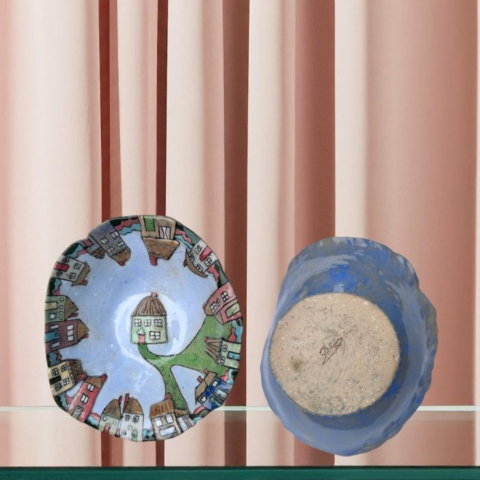 Colourful-Detailed ceramic dish with hand-painted homes, fences, and windows featuring a raised pale green house in the centre