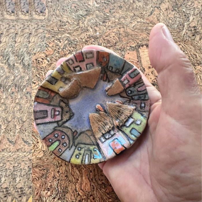Handmade ceramic dish with five vibrant, embossed houses raised from the surface.