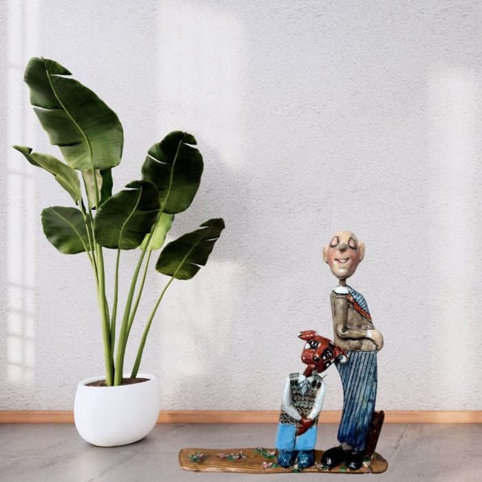 Handmade driftwood and ceramic sculpture of a man and dog, showcasing companionship and artistry.