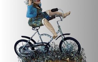 A woman sculpture with wire hair and an expressive face riding a ceramic bicycle.