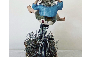 One-of-a-kind woman on bicycle sculpture that celebrates movement and fun.