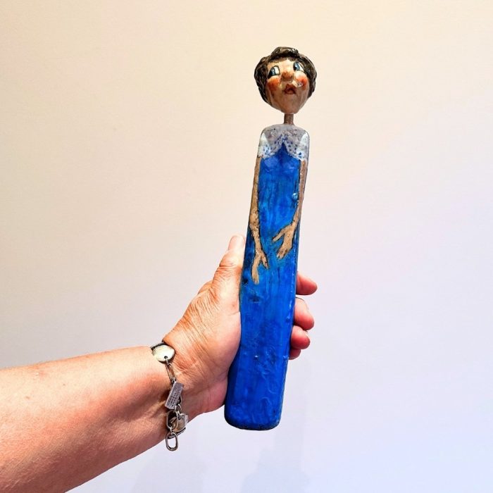 Handmade wooden and ceramic female figure for wall display.