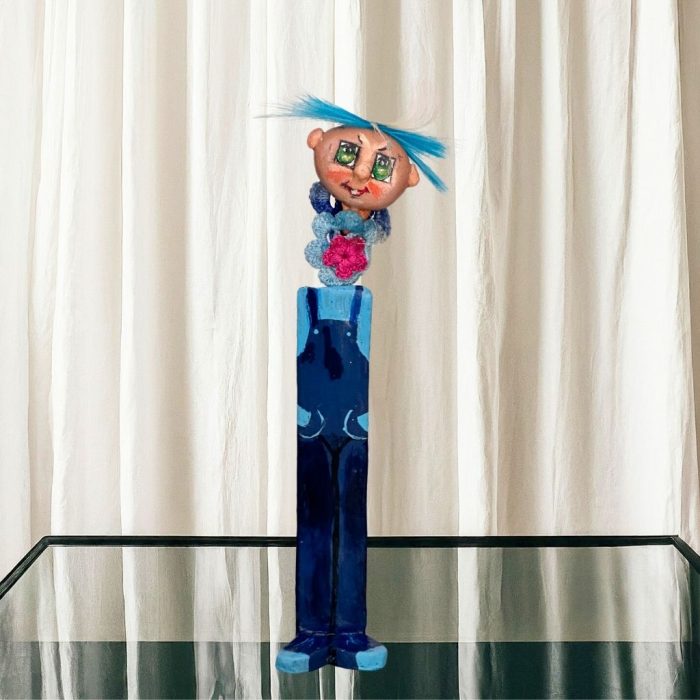 A whimsical ceramic flower figure with a colourful hand-painted stone face mounted on a ceramic body.