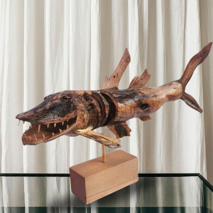 Hand-carved fish sculpture with deep wood grain textures.