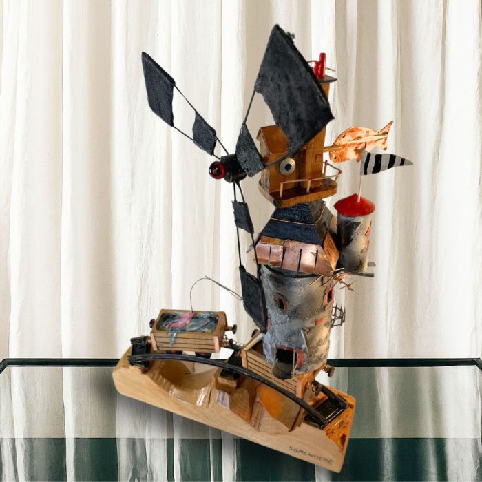 Handmade wooden windmill sculpture with a waving flag