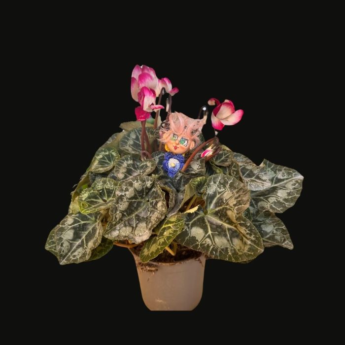 A whimsical ceramic flower figure with a colourful hand-painted stone face mounted on a ceramic body.